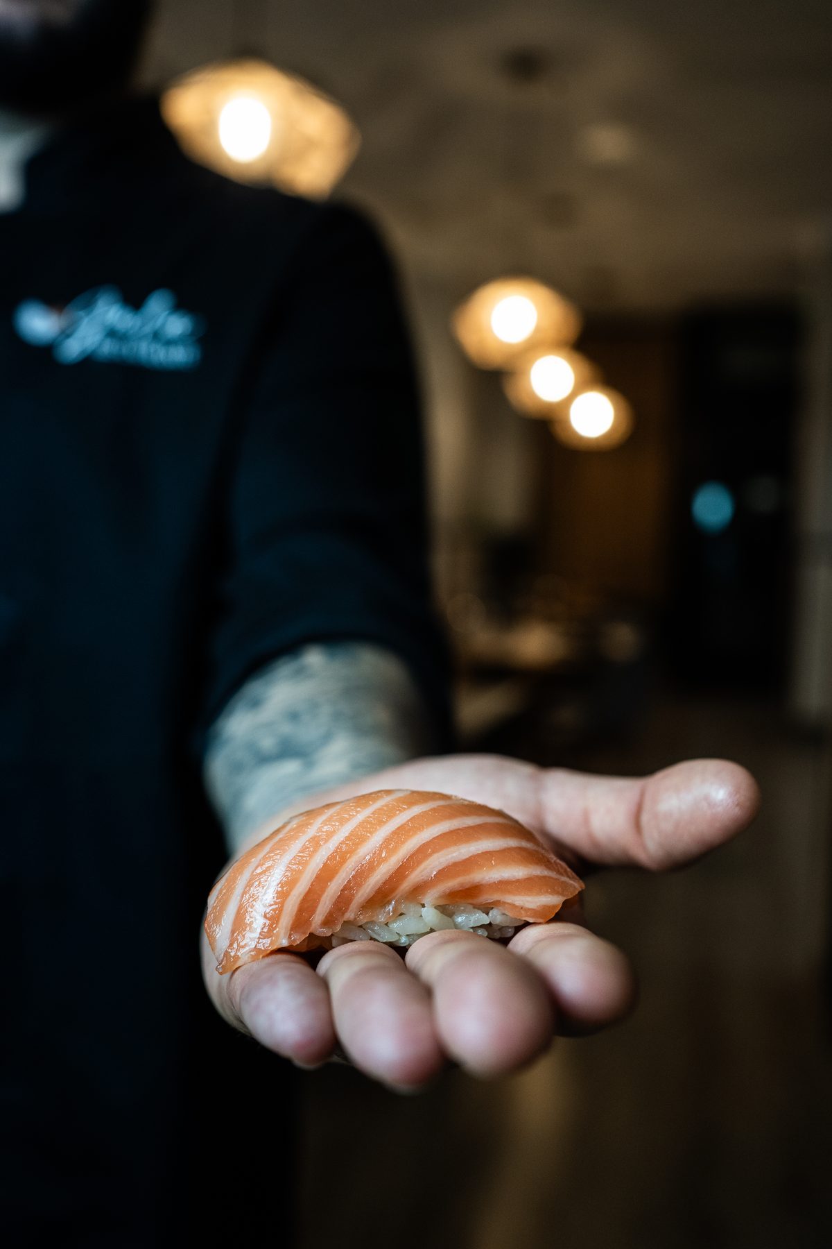 Itamae presentando un nigiri de salmón en el comedor de Gula