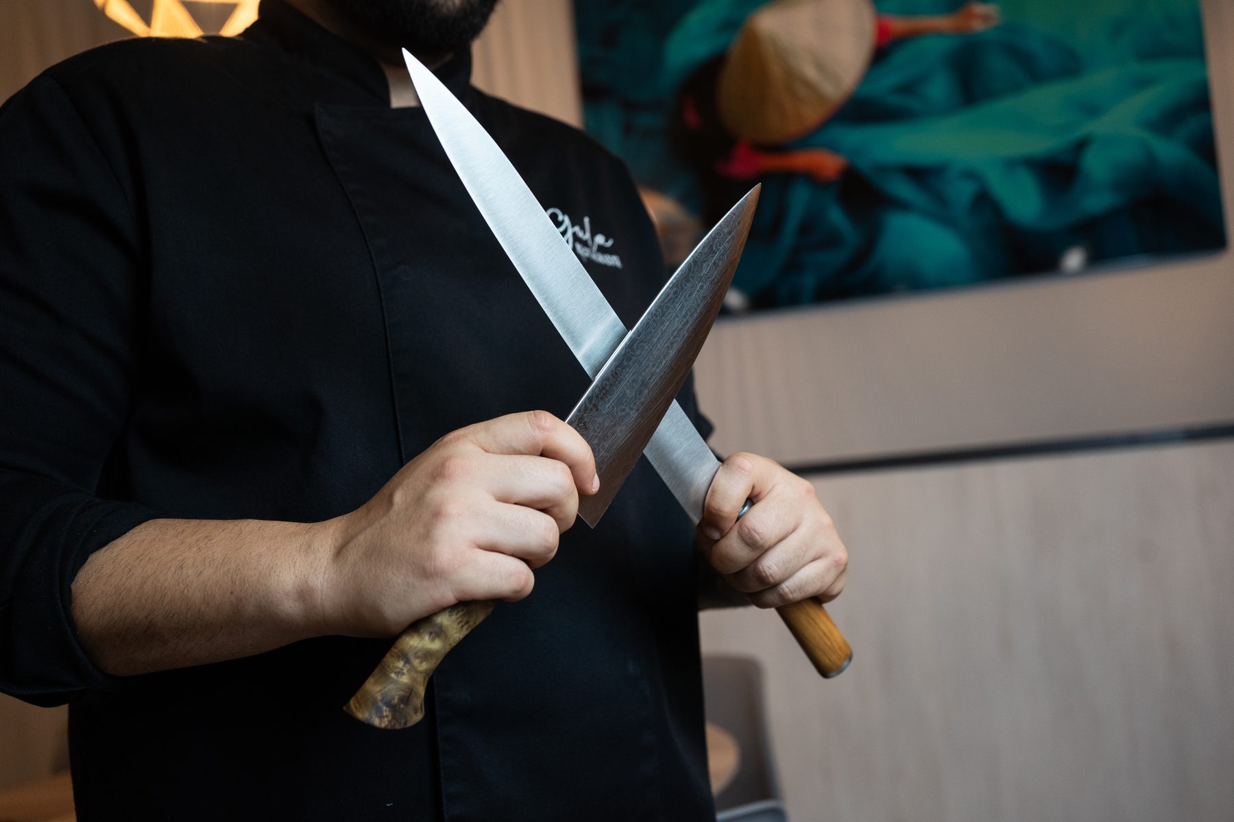 Manos del chef sosteniendo dos cuchillos japoneses