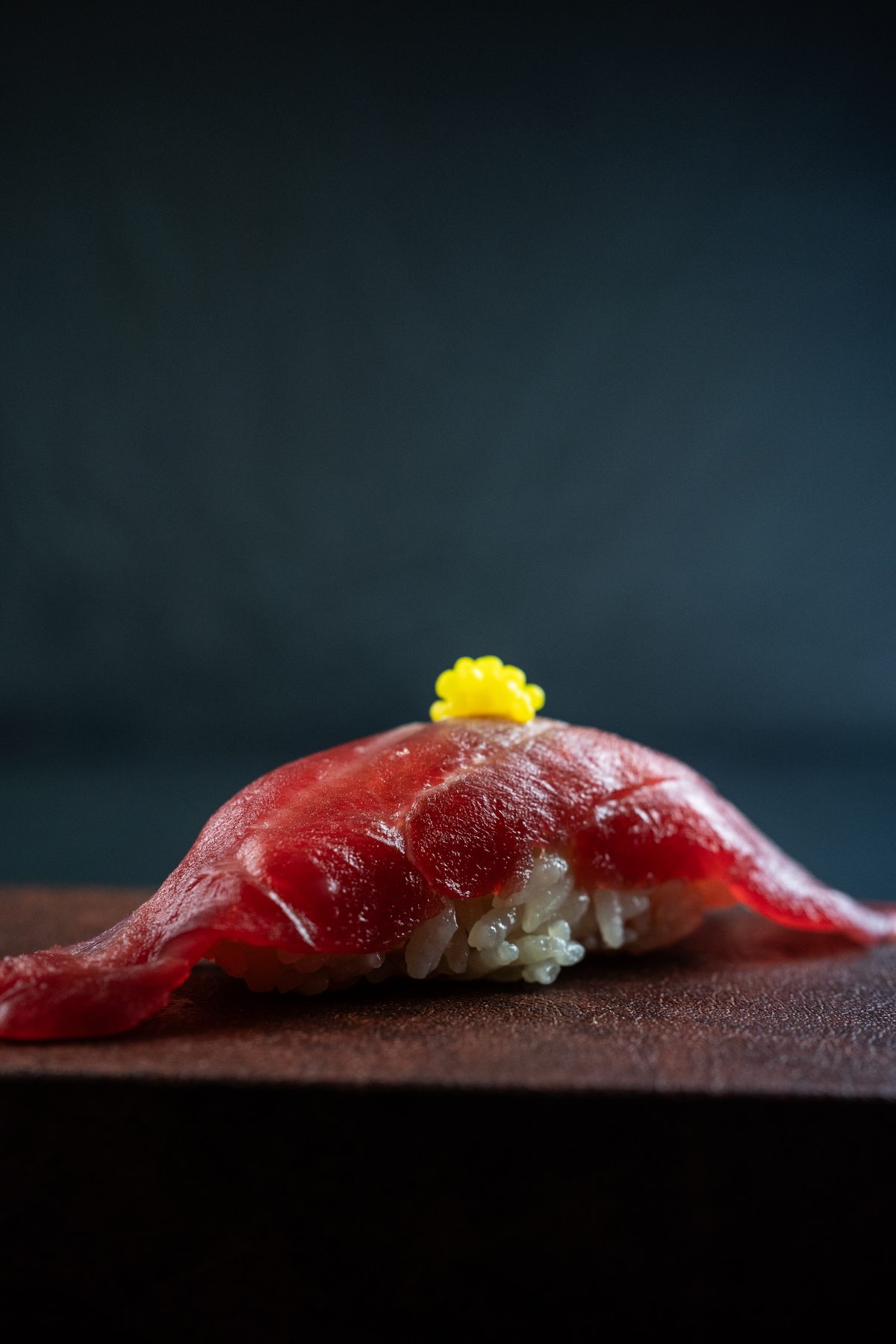 Nigiri de atún rojo con caviar cítrico sobre tabla de madera